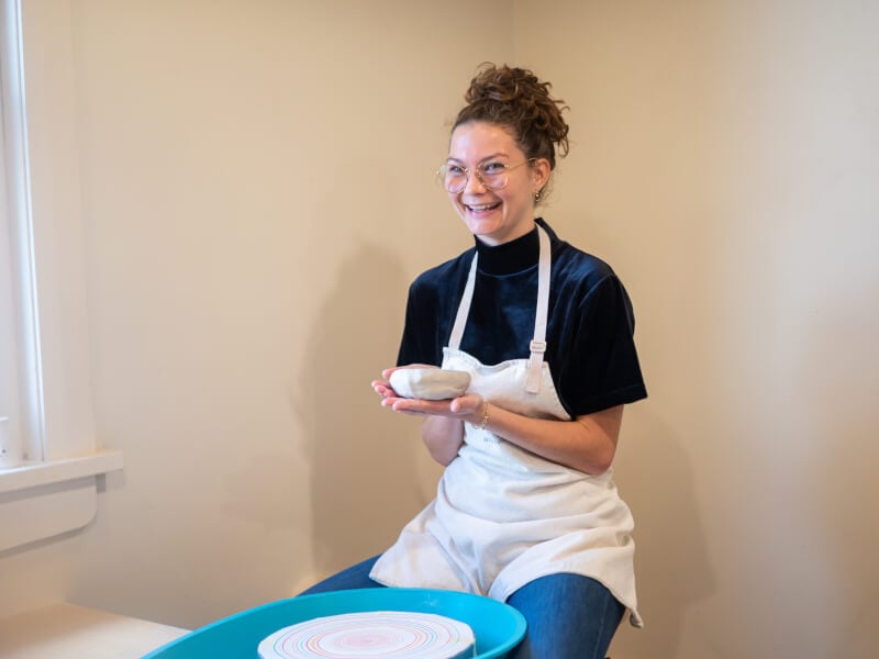 Woman smiling and holding hand building clay